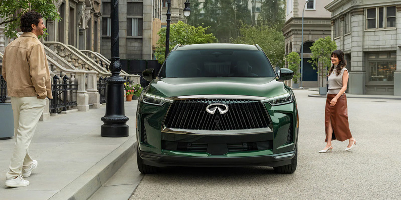 INFINITI SUV parked on city street with pedestrians