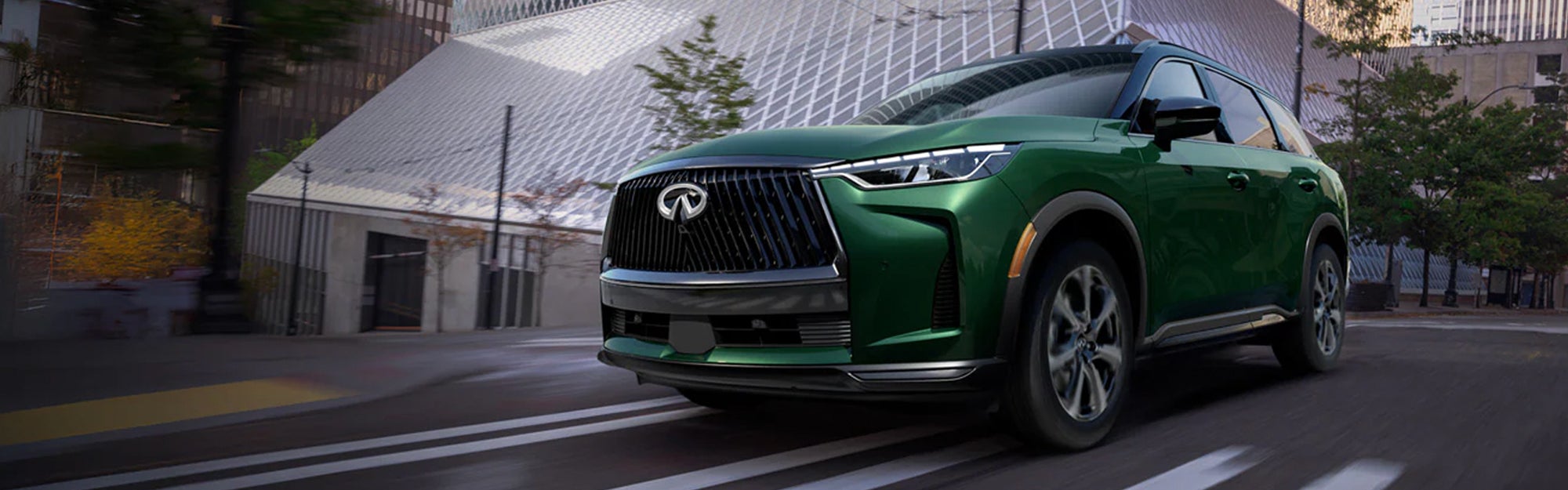 Green INFINITI SUV in city setting